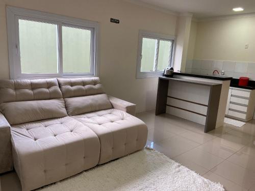 uma sala de estar com um sofá branco e uma mesa em Loft central Sant Helena Gramado Rs em Gramado