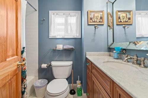 La salle de bains est pourvue de toilettes, d'un lavabo et d'un miroir. dans l'établissement Fairmount Neighborhood Gem, à Philadelphie