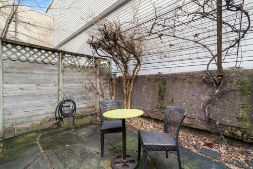 a table and chairs in a patio with a tree at Fairmount Neighborhood Gem in Philadelphia