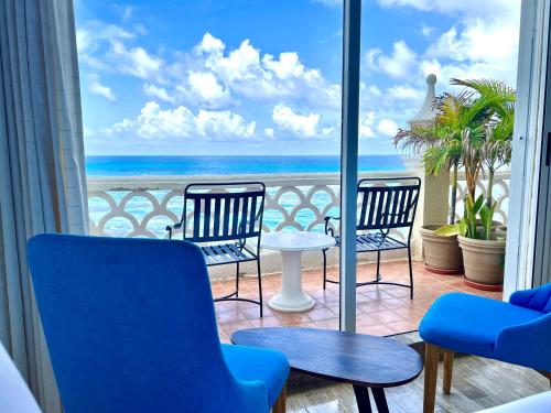 a balcony with chairs and a view of the ocean at Seashore Apartment Cancun in Cancún