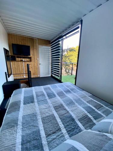 a bedroom with a large bed and a large window at Krukke Valdivia in Valdivia