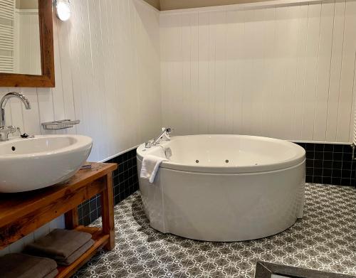 a bathroom with a large tub and a sink at Teades Plak bij De Herberg van Smallingerland in Rottevalle