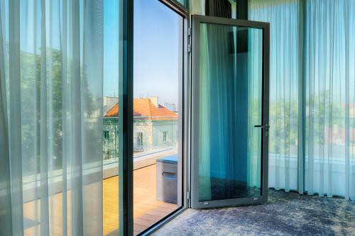 eine offene Glastür in einem Zimmer mit Balkon in der Unterkunft Focus Hotel Premium Sopot in Sopot