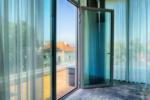 ソポトにあるFocus Hotel Premium Sopotのバルコニー付きの客室で、ガラスのドアが開きます。