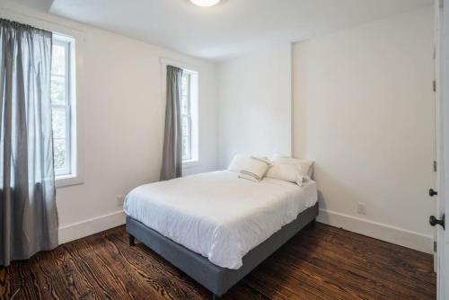 um quarto branco com uma cama e uma janela em Old City Gem 2 BR 1 5 BA,Perfect Location em Filadélfia