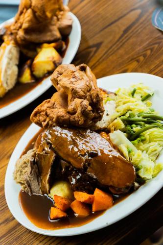 two plates of food with meat and vegetables on a table at The Peacock at Barlow in Chesterfield