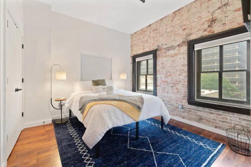 a bedroom with a bed and a brick wall at Luxurious Million Dollar Penthouse with Elevator and Parking in Philadelphia