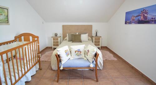 ein Schlafzimmer mit einem Bett und einem Kinderbett in der Unterkunft Casa Rural Manuela in As Mirans