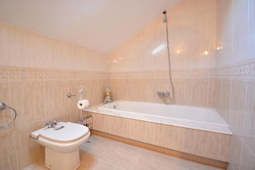 ein Badezimmer mit einer Badewanne, einem WC und einem Waschbecken in der Unterkunft Casa Rural Manuela in As Mirans