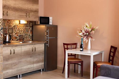 a kitchen with a small table and a refrigerator at Maya Panzio-Rezidencia in Szeged