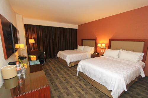 Кровать или кровати в номере Holiday Inn & Suites Plaza Mayor by IHG