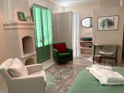 a living room with a green door and a green chair at Boutique Hotel Masseria Sottomasi in Savelletri di Fasano