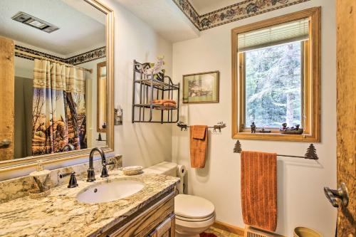 baño con lavabo y aseo y ventana en Tranquil Riverside Home with Wraparound Deck and Views en Baldwin