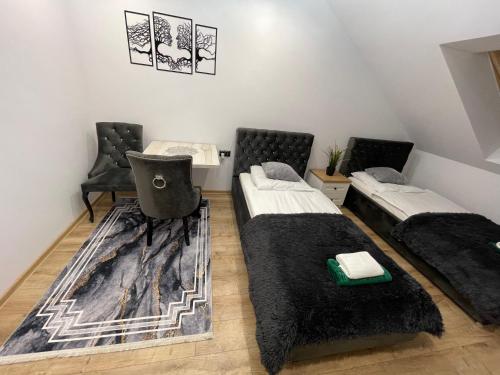 ein Zimmer mit 2 Betten und einem Stuhl darin in der Unterkunft Mały Książę in Podzamcze