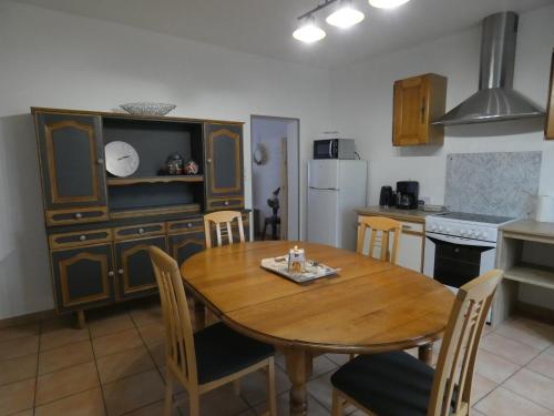 une cuisine avec une table en bois et une table et des chaises dans l'établissement Les chambres du héron, à Chevillon