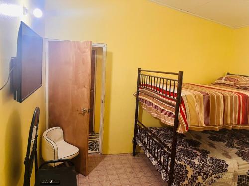 a bedroom with a bunk bed and yellow walls at City View Accomodations Apt 2 in Roseau