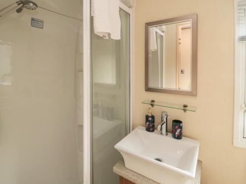 a white bathroom with a sink and a shower at Vista Retreat in Morpeth