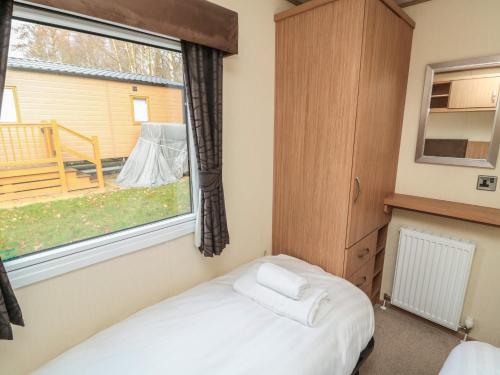 a small bedroom with a bed and a window at Vista Retreat in Morpeth