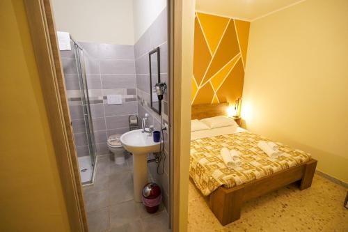 a bathroom with a bed and a sink and a toilet at Il Geranio b&b in Acconia