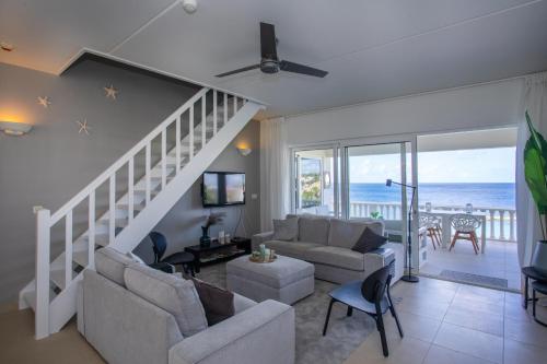 una sala de estar con una escalera que conduce al océano en Blue Bay Beach Apartments, en Blue Bay