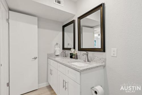uma casa de banho branca com um lavatório e um espelho em All the Essentials For You and Your Pet in Hyde Park em Austin