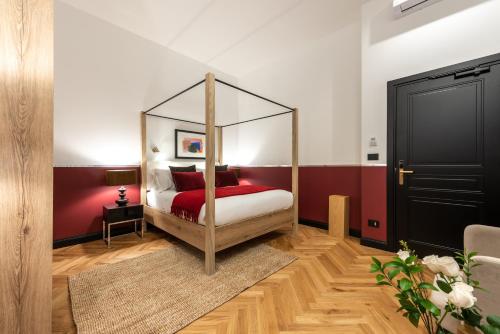 a bedroom with a canopy bed with red sheets at The Couper Castello in Milan