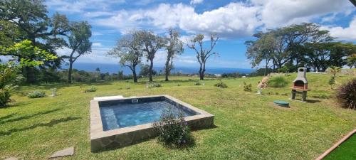 a garden with a swimming pool in the grass at Le Domaine de l'Ilet in Saint-Claude
