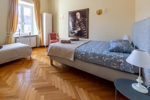 a bedroom with a bed and a table with a lamp at Apartament luster i obrazów in Warsaw