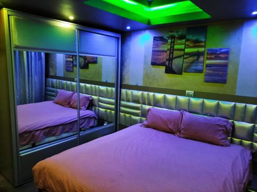 1 Schlafzimmer mit 2 Betten und grünem Licht in der Unterkunft Apartament Luxury in Constanţa
