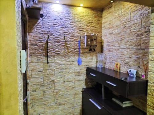 a bathroom with a stone wall and a black sink at Apartament Luxury in Constanţa