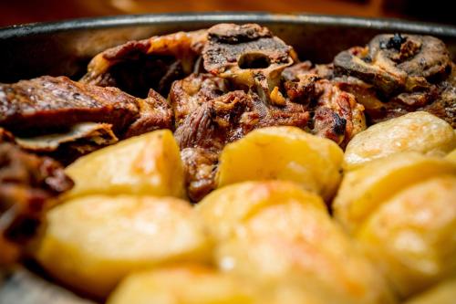 a pan of food with meat and potatoes at Revaklı Ev Guest House in Rizokarpaso