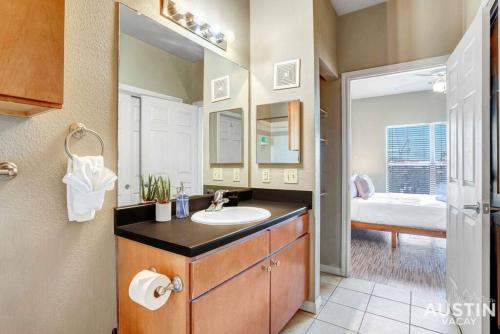a bathroom with a sink and a mirror and a bedroom at Space for 8 Near Downtown Easy Walk to UT Campus in Austin