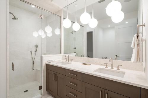 a bathroom with a sink and a shower and a mirror at Inspiration Point Townhome 8C in Big Sky