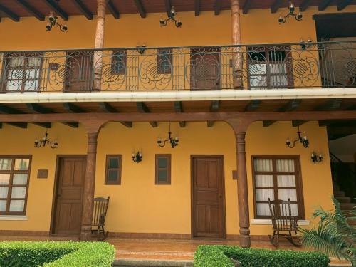 un bâtiment avec un balcon et des chaises. dans l'établissement Hotel Jardín de Tereza, à Comitán de Domínguez