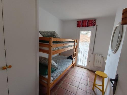 a room with a bunk bed in a room with a door at Pintoresco Apartamento en el corazón de Cadaqués in Cadaqués