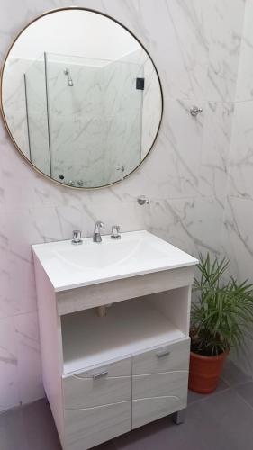 a bathroom with a white sink and a mirror at Casa de Hugo in Cafayate