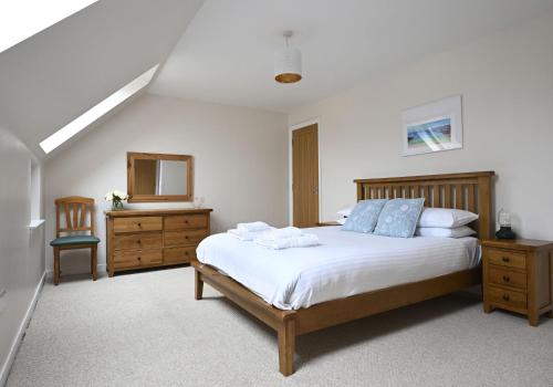 ein Schlafzimmer mit einem Bett, einer Kommode und einem Spiegel in der Unterkunft Sugarloaf in Fort William