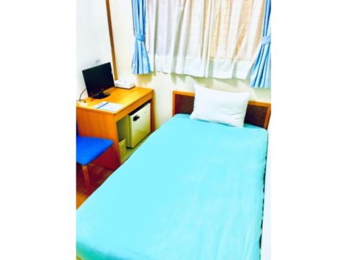 a bedroom with a bed and a desk with a computer at Ishigakijima no Sudomari Orihimeno Yado - Vacation STAY 68049v in Ishigaki Island