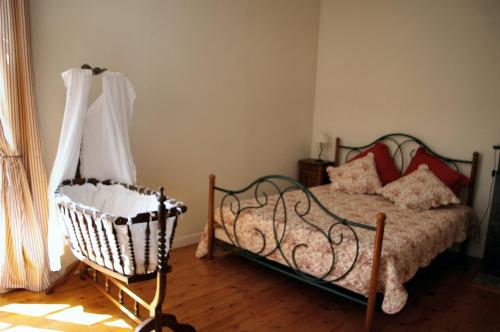 a bedroom with a bed and a chair and a window at Grande Maison Mirabelensis - chambres d'hôtes in Mirabel