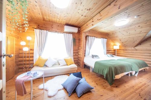 a bedroom with two beds in a log cabin at Awaji Large Loghouse in Goshiki - Vacation STAY 64354v in Sumoto