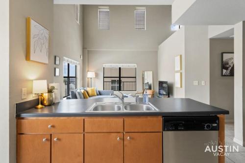 a kitchen with a sink and a dishwasher at Perfect Location Near UT and Large Patio With A View in Austin
