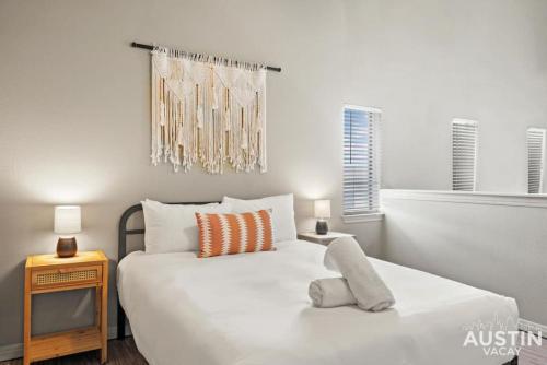 1 dormitorio con 1 cama blanca grande y TV en Perfect Location Near UT and Large Patio With A View en Austin