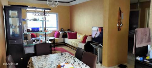 sala de estar con sofá y mesa con sillas en APPARTEMENT ARRAJA, en Casablanca