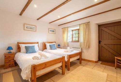 GwennapにあるChurch Close Cottageのベッドルーム1室(ベッド2台付)、納屋のドアが備わります。