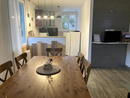 a dining room and kitchen with a wooden table and chairs at Appartement Rebouc in Hèches