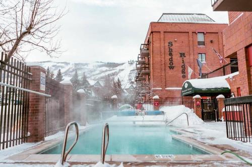 a swimming pool covered in snow next to a building at Ski-In Ski Out Luxury 1 Bd / 2 ba Condo in Park City