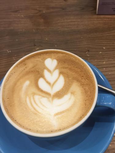 Una taza de café en un plato azul con un corazón pintado en él. en Pension Pichler, en Sillian