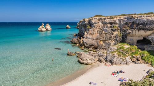 a group of people on a beach next to the ocean at HOLLY CASA VACANZE TORRE DELL'ORSO in Torre dell'Orso