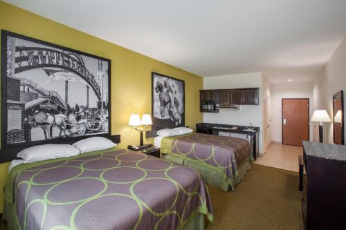 a hotel room with two beds and a kitchen at Scottish Inns and Suites - La Porte in La Porte