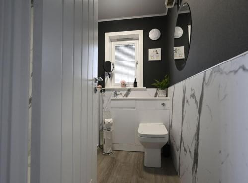 een badkamer met een wit toilet en een wastafel bij Sealladh Mairi in Fort William